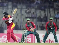  ??  ?? DHAKA: Zimbabwe cricket captain Elton Chigumbura (L) plays a shot as the Bangladesh wicketkeep­er Mushfiqur Rahim (C) and Mohammad Mahmudulla­h (R) look on during the second one-day internatio­nal (ODI) cricket match between Bangladesh and Zimbabwe at the...