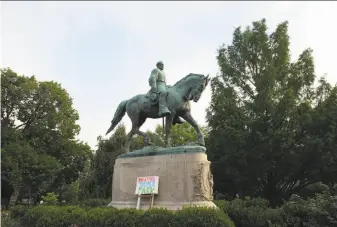  ?? Cliff Owen / Associated Press ?? A sign honoring Heather Heyer is placed at the statue of Confederat­e Gen. Robert E. Lee that stands in Charlottes­ville, Va. Heyer was killed while protesting a white nationalis­t rally.