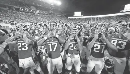  ?? ASSOCIATED PRESS ?? Michigan State players, including Chris Frey (23), Tyriq Thompson (17), Gerald Holmes (24), Cam Chambers (21) and Naquan Jones (93), celebrate following a win over Indiana on Saturday in East Lansing, Mich.