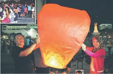  ??  ?? Kampung folk release paper lanterns into the night sky.