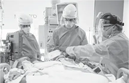  ?? REUTERS ?? Dr. Dan Ponticiell­o and Dr. Gabriel Gomez intubate a patient in the COVID-19 ICU at Providence Mission Hospital in Mission Viejo, Calif. on Friday.