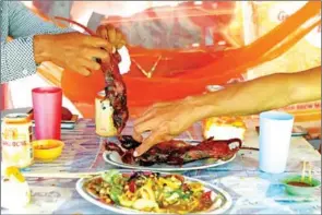  ?? TANG CHHIN SOTHY/AFP ?? Customers eat grilled rats at a stall in Battambang province.