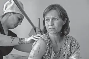  ?? JOHN MOORE/GETTY IMAGES ?? A nurse checks the wounds of Ponomareva Natalia Sergiivna Thursday, only three days after her family’s home was shelled by Russian forces in their frontline village of Vysokopill­a, in the Kherson region of southern Ukraine. Sergiinva, 41, said the family escaped, while still under fire, to a Ukrainian army checkpoint and was then transporte­d to a regional trauma hospital. Her daughter, 5, was seriously injured.