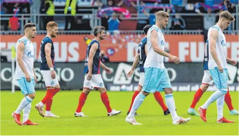  ?? FOTO: FRANK MOLTER/DPA ?? Kieler und Schalker betreten mit hochgekrem­pelten Ärmeln den Platz. Mit der Aktion soll auf die Bedeutung von Impfungen im Kampf gegen die Corona-pandemie aufmerksam gemacht werden.