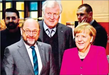  ?? JOHN MACDOUGALL/AFP ?? German Chancellor and leader of the Christian Democratic Union Angela Merkel (right) poses with the leader of the Social Democratic Party Martin Schulz (left) and the chairman of the Bavarian Christian Social Union Horst Seehofer (centre) before...