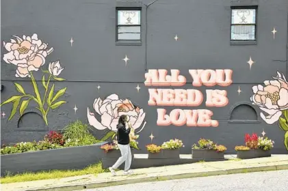  ?? ?? Mike Koletar, the second-generation owner of The Flower Cart in the 5200 block of Harford Road, commission­ed Baltimore artist Marshall Adams to paint this mural on the north side of his shop. Koletar’s father, Fred Koletar, started the florist shop in Hamilton in 1961.