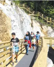  ?? STAFF PHOTO BY ERIN O. SMITH ?? Visitors make their way down a new walkway at Ruby Falls Friday on Lookout Mountain. The attraction, which sees about 500,000 visitors a year, according to Ruby Falls officials, has undergone an expansion including the walkway which leads to an overlook area.