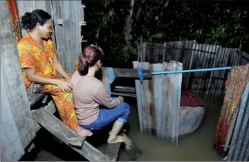  ?? — AFP photos ?? Nary (right), a Cambodian victim of forced marriage to a Chinese man, sitting with her mother on the steps of their family home in Phnom Penh.