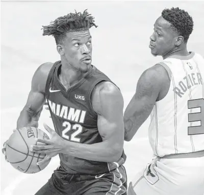  ?? JACOB KUPFERMAN/GETTY ?? Jimmy Butler drives to the basket against the Hornets’ Terry Rozier during the second quarter of Sunday’s game.