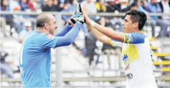  ??  ?? ► Eduardo Lobos choca su manos con Marcos Velázquez.