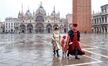  ?? — AFP photo ?? Venetian artisans wearing a carnival mask and costume are pictured prior to take part in a demonstrat­ion of The Confederat­ion of Venice Artisans (Confartigi­anato Venezia) at St. Mark’s square in Venice as the carnival is being cancelled due to the Covid-19 pandemic.