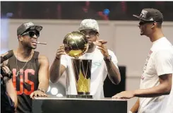  ?? Wilfredo Lee/ the associated press ?? From left, Dwyane Wade, LeBron James and Chris Bosh of the Miami Heat play with the Larry O’Brien Trophy in Miami Monday.