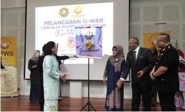  ??  ?? Dr Yaw (front left) watches the banner unfurl when launching the state-level Women Against Corruption (G-War) programme. With her are Razim (second right), Norjanah (second left) and Zulhairy (right).