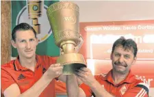  ?? FOTO: DPA ?? Christian Zech (li.) und Thomas Wieser präsentier­en den Pokal.