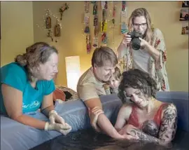  ?? Allison Zaucha For The Times ?? STEPHANIE ENTIN photograph­s the Kaiser family, alongside midwife Mary Lou O’Brien, left, after Luna Sofia was born at the family’s Redondo Beach home.