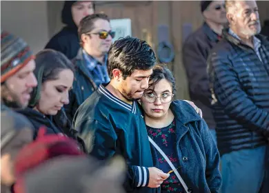  ?? ?? ABOVE: Dylan Schwaegel, left, and Magdalena Archuleta embrace Thursday while the names of 36 homeless Santa Feans who died this year are read aloud at the Shrine of Our Lady of Guadalupe downtown. About 100 people attended the vigil.