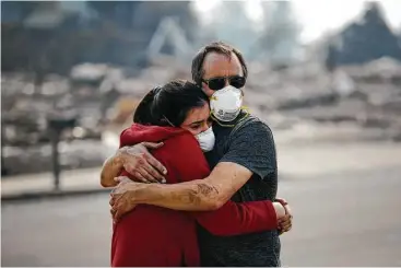  ?? Jae C. Hong / Associated Press ?? Howard Lasker comforts his daughter, Gabrielle, as they visit the remains of their home Sunday for the first time since a wildfire swept through their neighborho­od in Santa Rosa, Calif.