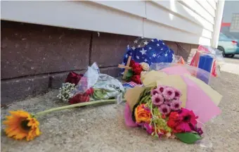  ??  ?? HEAVY HEARTS: Flowers lay in an alley off of Shirley Street in honor of retired State Trooper David Green who was shot and killed Saturday along with Air Force Staff Sgt. Ramona Cooper, before police killed the shooter.