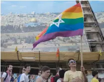  ?? (Baz Ratner/Reuters) ?? A MAN holds an Israeli flag with Pride colors.