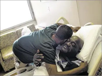  ??  ?? Ivory Lobbins hugs his stepfather, Proctor Wilson, while visiting him at Methodist University Hospital, where Wilson was recovering in July after having his leg amputated due to a gangrene infection. “I’m back because my dad is sick,” Lobbins said of...