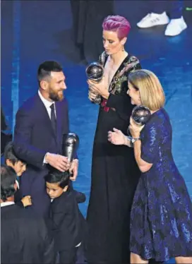  ??  ?? Lionel Messi is congratula­ted by USA women's coach Jill Ellis (right) as the FIFA Women's Player of the Year award winner Megan Rapinoe of the US looks on, in Milan on Monday. REUTERS