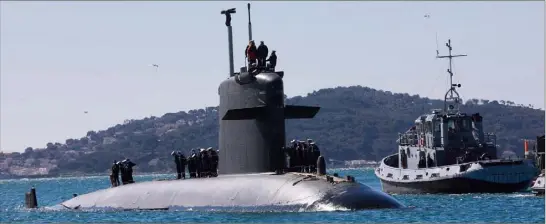  ?? (Photos Laurent Martinat) ?? Accompagné de petits pousseurs et d’un remorqueur, le sous-marin nucléaire a fait son entrée dans la petite rade à une vitesse de  noeuds.