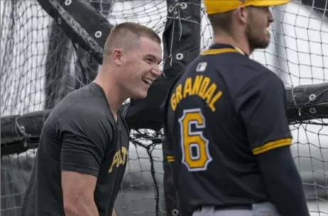  ?? Benjamin B. Braun/Post-Gazette ?? Pirates catchers Henry Davis, left, shares a laugh with Yasmani Grandal outside of a batting cage at Pirate City during spring training on Feb. 17 in Bradenton, Fla.