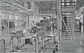  ?? NICOLE HESTER / THE TENNESSEAN ?? An employee rides a bike inside the electric vehicle battery plant at GM Spring Hill Manufactur­ing in Spring Hill on Jan. 23.