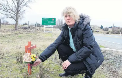  ?? PHOTO: JONO EDWARDS ?? Tribute . . . Alexandra woman Kate Jensen lays flowers on a cross at the intersecti­on where her exhusband was killed.