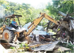  ??  ?? JENTERA berat merobohkan struktur rumah setinggan semasa operasi perobohan di Kampung Kibagu Manggatal.