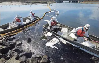  ?? Ringo H.W. Chiu / Associated Press ?? Cleanup contractor­s deploy skimmers and floating barriers known as booms to try to stop further oil crude incursion into the Wetlands Talbert Marsh in Huntington Beach, Calif., on Sunday.