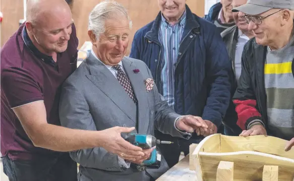  ?? Picture: GETTY IMAGES ?? Prince Charles uses a power driver to put screws into an ornamental wheelbarro­w in Gortin during his tour of Northern Ireland.