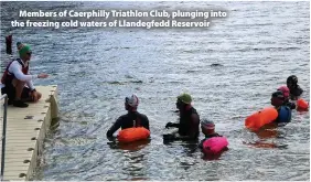  ??  ?? > Members of Caerphilly Triathlon Club, plunging into the freezing cold waters of Llandegfed­d Reservoir