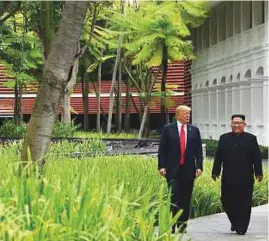  ?? AFP, Reuters ?? Right: Trump and Kim take a walk after their working lunch at the Capella Hotel on Sentosa island in Singapore yesterday.