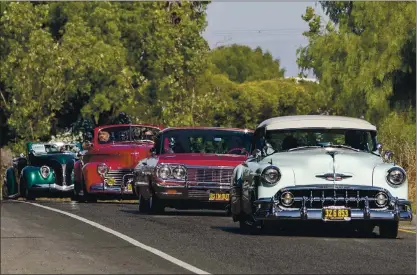  ?? PHOTOS BY KARL MONDON — STAFF PHOTOGRAPH­ER ?? David Polanco drives his ’53Bel Air at the head of a caravan of San Jose lowriders taking food and supplies to farmworker­s in Gilroy on Saturday.