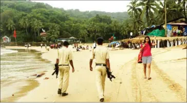  ?? INDRANIL MUKHERJEE/AFP ?? Armed Indian police officers patrol Baga Beach in Goa on September 25. Goa has long attracted Western holidaymak­ers for its relaxed vibe. But rapid constructi­on, swelling crowds and fears over safety are threatenin­g the Indian state’s global reputation...