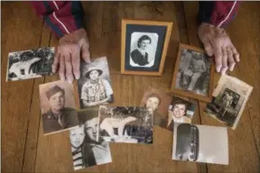  ??  ?? Jean-Francois Badias In this photo taken May 8, 2019, Andre Gantois shows family photos, including one of his mother Irene Gantois, top center, in Ludres, eastern France. The retired French postal worker figured he’d likely go to his grave without ever knowing who his father was, unable to identify the U.S. serviceman who had fought his way across France after the D-Day landings, taken a bullet to the skull and been nursed back to health in a military hospital by Gantois’ mother.