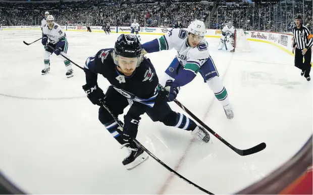  ?? JOHN WOODS/THE CANADIAN PRESS ?? Kyle Connor and the Winnipeg Jets were able to spin away from Ben Hutton and the Vancouver Canucks in the third period Thursday night, scoring three goals to notch a 4-1 victory over their Canadian rivals at Bell MTC Centre in Winnipeg.