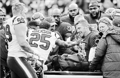  ?? MARK TENALLY THE ASSOCIATED PRESS ?? Houston Texans strong safety Kareem Jackson reaches for Washington Redskins quarterbac­k Alex Smith as he leaves the field after Jackson’s tackle caused Smith to suffer a badly broken leg.