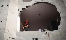  ?? AFP ?? A man sweeps away rubble after a building was damaged by an Israeli strike in Rafah, southern Gaza,