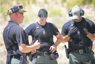  ?? GABRIELA CAMPOS/THE NEW MEXICAN ?? Pre-academy cadets Alan Scott and Donald Lindsey receive feedback from William Cordova during firearm drills Wednesday afternoon.