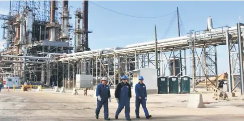  ??  ?? Refinery workers walk inside the LyondellBa­sell oil refinery in Houston, Texas. — Reuters photo