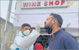  ?? HT PHOTO ?? A medic collects sample from a customer outside a liquor shop in Samba on Friday.