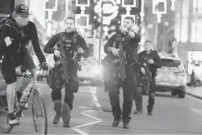  ?? — Gambar AFP ?? CETUS PANIK: Polis mengarahka­n orang awam mengikuti arahan selepas satu insiden pergaduhan mencetuska­n situasi panik di Oxford Circus, tengah London ketika orang ramai asyik membeli-belah semalam.