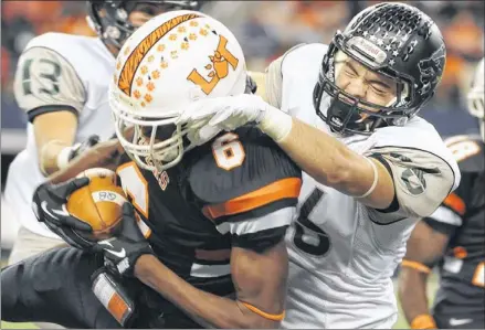  ?? ASHLEY LANDIS / FOR AMERICAN-STATESMAN ?? Cedar Park’s Grayson Cotham (right) tackles Lancaster’s Nick Alexander (6) during the Timberwolv­es’ UIL Class 4A, Division II state championsh­ip victory at Cowboys Stadium in Arlington on Friday night.