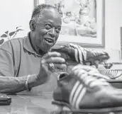  ?? Mark Mulligan / Staff photograph­er ?? Donald Dickson shows off a pair of cleats he wore while playing football for Yates.