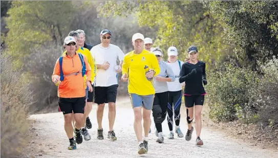  ?? Jenna Schoenefel­d
For The Times ?? LONG- RUN ENTHUSIAST
David Leon Moore, in yellow at center, runs Crags Road in Malibu Creek State Park with a group of friends on a recent Saturday.