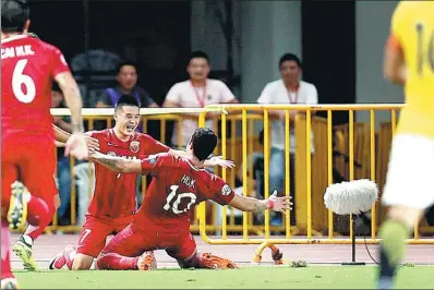  ?? FAN JUN / XINHUA ?? Wu Lei celebrates with teammate Hulk after scoring in Tuesday’s AFC Champions League quarterfin­al first-leg match against Guangzhou Evergrande in Shanghai. SIPG cruised to a 4-0 triumph.
