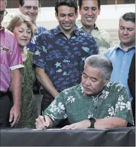  ?? Audrey Mcavoy ?? The Associated Press Hawaii Gov. David Ige signs legislatio­n Tuesday in Honolulu banning the sale of sunscreens containing the chemicals oxybenzone and octinoxate, which are believed to harm coral reefs. The prohibitio­n will take effect in 2021.