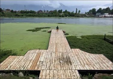  ?? A man fishes from the algae-covered Nigeen Lake in Srinagar on Friday. ??